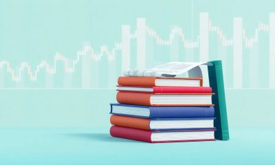Pilha de livros sobre trading e análise técnica com gráficos de mercado financeiro